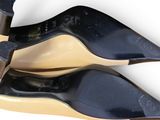 two pairs of black high heeled shoes on top of each other