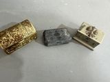 trois types différents de bijoux sont posés sur une surface blanche