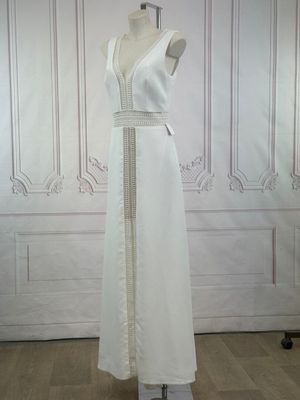 a dress on a mannequin stand in front of a wall