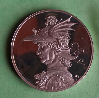 a silver coin with a picture of a woman wearing a hat