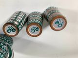 four rolls of green and white thread sitting on top of a white surface