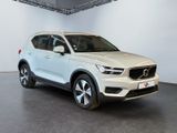 a white volvo suv parked in a showroom