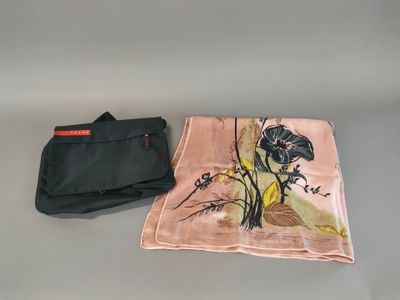 a pink scarf and a black bag on a table