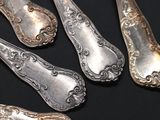 five silver spoons and a fork on a black surface