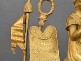 a gold clock with a statue on top of it