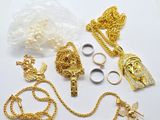 a lot of gold jewelry on a white surface