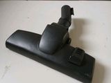 a close up of a black vacuum cleaner on a white surface