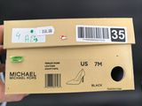someone is holding a box with a pair of shoes on it