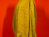 an image of a yellow jacket on a mannequin stand against a red wall