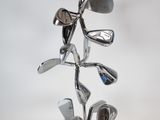 a metal sculpture of golf clubs on a stand