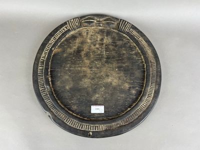une assiette noire et dorée posée sur une table blanche
