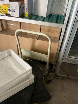 a white cart sitting next to a stack of boxes on a floor