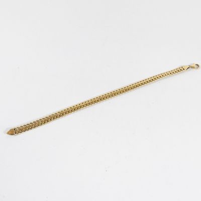 un bracelet en or avec une chaîne sur fond blanc
