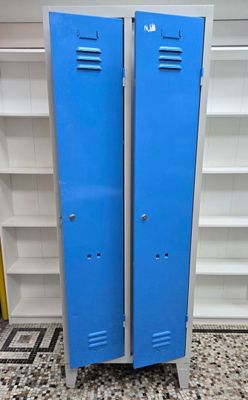 two blue lockers in the middle of a tiled floor