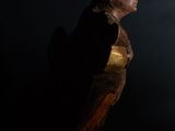 statue of a woman in a dark room with a black background