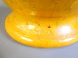 un vase jaune posé sur une table