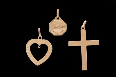 trois types différents de pendentifs en forme de croix et de cœur sur fond noir