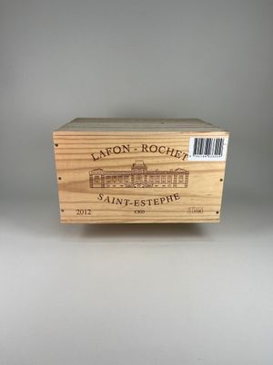 La boîte en bois contient une bouteille de vin posée sur une surface blanche.