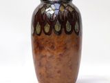 a brown vase that is sitting on a white surface