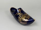 a blue clogger with a gold design on it