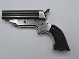 an old revolver with a black handle on a white surface