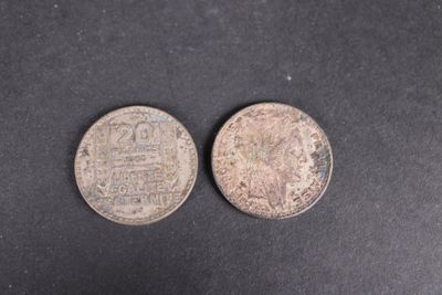 deux vieilles pièces d'argent sur une surface noire