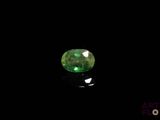 a green emerald stone on a black surface