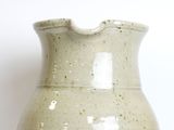 a white vase sitting on a table with a white background