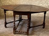 a wooden table with a wooden top on a brick floor