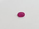 a pink oval stone on a white surface