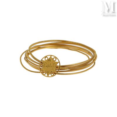 gros plan d'un bracelet en or sur fond blanc