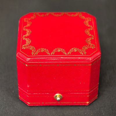une petite boîte rouge ornée d'un motif doré