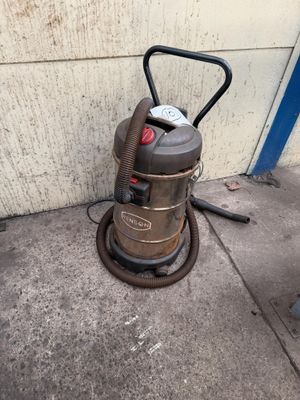 a vacuum that is sitting on the sidewalk next to a wall