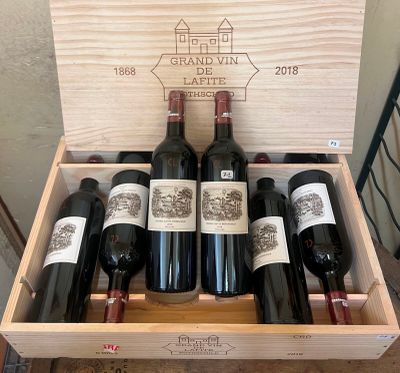 several bottles of wine are in a wooden box on a table