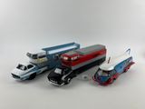 Plusieurs petites voitures et camions sont alignés sur une surface blanche