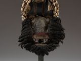 a close up of a mask on a stand on a white surface