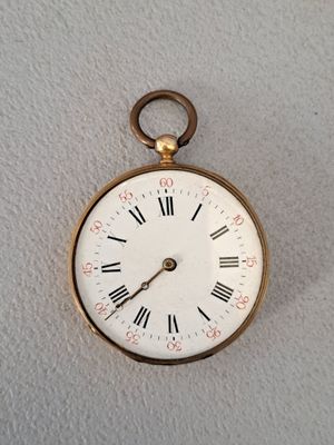 une montre de poche en or avec des chiffres romains sur le cadran