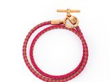 un bracelet rose avec un fermoir doré sur fond blanc
