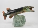 statue of a fish on a rock with its mouth open