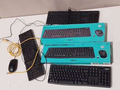 three keyboards and a mouse sitting on a table