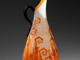 un vase orange et blanc posé sur une table