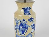 a blue and white vase with a light on it