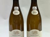 two bottles of white wine sitting next to each other on a table
