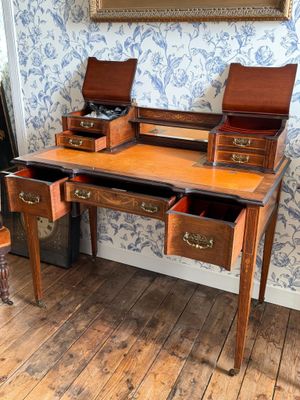 un bureau en bois à deux tiroirs et un miroir accroché au mur