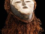 une image représentant un masque blanc avec des cheveux bruns sur fond noir