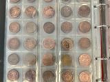 a lot of coins in a binder on a table