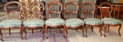 six chaises posées sur un tapis dans une pièce