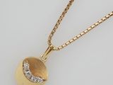 an 18k gold pendant with a diamond ball and chain