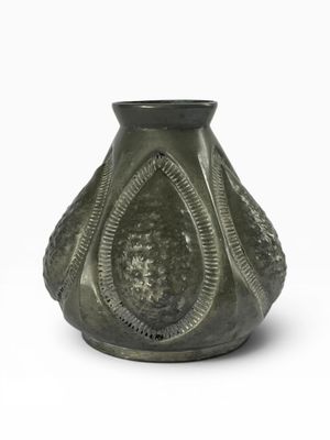 un vase vert posé sur une surface blanche