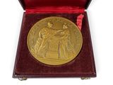 an image of a gold medal in a red box on a white background
